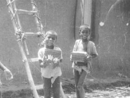 Bondka and friend carrying tiles, c1968